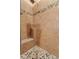 Shower featuring natural stone pebble accents and a built-in seat in the shower at 4111 N Starry Pass Cir, Mesa, AZ 85207