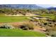 Picturesque golf course view featuring lush green fairways, sand traps, and mountain views in a desert setting at 41908 N Harbour Town Ct, Anthem, AZ 85086