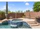 Backyard hot tub surrounded by rock waterfall and desert landscaping at 41908 N Harbour Town Ct, Anthem, AZ 85086