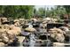 Beautiful water feature with cascading rocks and lush greenery, creating a tranquil and scenic environment at 41908 N Harbour Town Ct, Anthem, AZ 85086