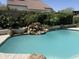 Refreshing backyard pool features a rock waterfall, surrounded by lush greenery, offering a private oasis at 4223 E Wildcat Dr, Cave Creek, AZ 85331