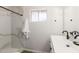 Modern bathroom with marble tile shower, sleek white vanity, and black hardware fixtures at 506 W Seldon Ln, Phoenix, AZ 85021