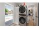 Convenient laundry room with stacked washer and dryer, providing easy access to the backyard pool area at 506 W Seldon Ln, Phoenix, AZ 85021