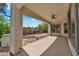 Covered back patio with a ceiling fan and serene views of the landscaped backyard and desert beyond at 5312 S Citrus Ct, Gilbert, AZ 85298