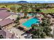 Aerial shot of a community pool, lawn bowling, and clubhouse in a desert setting with mountain views at 5312 S Citrus Ct, Gilbert, AZ 85298