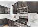 Gourmet kitchen featuring stainless steel appliances, black cabinets, and white countertops at 5312 S Citrus Ct, Gilbert, AZ 85298