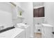 Bright laundry room with white washer and dryer, upper cabinets, a utility sink, and tiled floors at 5312 S Citrus Ct, Gilbert, AZ 85298