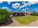 Well-maintained backyard featuring a covered patio, lush lawn, decorative rock and landscape, and clear blue skies at 5601 W Whitten St, Chandler, AZ 85226