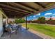 Large covered patio overlooking a grassy backyard with lush landscaping at 5601 W Whitten St, Chandler, AZ 85226