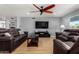 Spacious living room with hardwood floors, comfortable seating, and a large flat-screen TV at 5601 W Whitten St, Chandler, AZ 85226