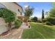 Private backyard boasts mature trees, lush landscaping, and a covered patio for comfortable outdoor living at 630 W Navarro Ave, Mesa, AZ 85210