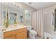 Well-lit bathroom with a vanity, shower with curtain, and decorative elements at 630 W Navarro Ave, Mesa, AZ 85210