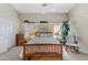 Bright bedroom featuring wood furniture, neutral walls, decor shelving, and a ceiling fan at 630 W Navarro Ave, Mesa, AZ 85210