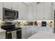 Bright kitchen with white cabinets and modern stainless steel appliances on countertops at 630 W Navarro Ave, Mesa, AZ 85210
