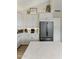 Modern kitchen with stainless steel refrigerator, decorative storage, and white cabinetry at 630 W Navarro Ave, Mesa, AZ 85210