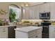 Bright kitchen with white cabinets, a stylish backsplash, and a view of the outdoors at 630 W Navarro Ave, Mesa, AZ 85210