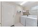 Functional laundry room with a washer, dryer, and storage shelf at 630 W Navarro Ave, Mesa, AZ 85210
