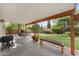 Covered patio includes an outdoor dining area, bench seating, and views of the landscaped backyard at 630 W Navarro Ave, Mesa, AZ 85210