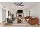 Bright living room featuring a stone fireplace, modern ceiling fan, and stylish furnishings at 6550 N 7Th St, Phoenix, AZ 85014