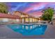 An inviting pool reflects the lovely sunset sky surrounding this beautiful brick home at 6550 N 7Th St, Phoenix, AZ 85014