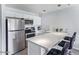 Modern kitchen with stainless steel appliances, white cabinets, and breakfast bar seating at 8055 E Thomas Rd # D111, Scottsdale, AZ 85251