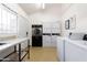 Bright laundry room featuring multiple machines, a granite countertop, and ample space for convenient chore completion at 8055 E Thomas Rd # D111, Scottsdale, AZ 85251