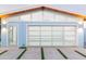 Modern home garage with a glass door and clerestory windows, set against a sleek concrete driveway with grass accents at 8308 E Mariposa Dr, Scottsdale, AZ 85251