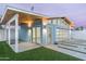 Garage features a glass door and an open-air wood beam structure, connecting to a manicured lawn and driveway at 8308 E Mariposa Dr, Scottsdale, AZ 85251