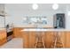 Sleek kitchen featuring modern appliances, wooden cabinetry, and a stylish breakfast bar at 8308 E Mariposa Dr, Scottsdale, AZ 85251