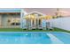 Relaxing backyard pool area with lounge chairs, umbrellas, and a modern blue home design, perfect for outdoor living at 8308 E Mariposa Dr, Scottsdale, AZ 85251