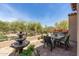 Secluded backyard featuring a water fountain and an outdoor dining area with picturesque desert and mountain views at 8974 E Rusty Spur Pl, Scottsdale, AZ 85255