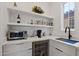 Butler's pantry with white cabinets, countertops, shelves, sink, and wine fridge at 8974 E Rusty Spur Pl, Scottsdale, AZ 85255