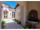 Charming front entry featuring a private courtyard with a stone fountain and lush greenery offering an inviting welcome at 8974 E Rusty Spur Pl, Scottsdale, AZ 85255