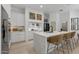 Modern white kitchen boasts marble countertops, stainless steel appliances, and seating at the island at 8974 E Rusty Spur Pl, Scottsdale, AZ 85255