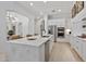 Open-concept kitchen with a large marble island, stainless steel appliances, and sleek white cabinets at 8974 E Rusty Spur Pl, Scottsdale, AZ 85255