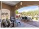 Inviting covered patio featuring comfortable seating and an outdoor dining area with a view of the serene desert landscape at 8974 E Rusty Spur Pl, Scottsdale, AZ 85255