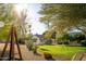 A well-maintained backyard featuring green lawn, a windmill, and mature trees at 9035 W Villa Chula --, Peoria, AZ 85383