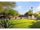 Lush backyard with green grass, desert landscaping, and mature trees at 9035 W Villa Chula --, Peoria, AZ 85383