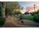 Beautiful backyard at sunset featuring lush landscaping, walking path, and desert flora at 9035 W Villa Chula --, Peoria, AZ 85383