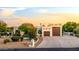 Southwestern home featuring a concrete driveway, three-car garage, and desert landscaping under a bright sky at 9035 W Villa Chula --, Peoria, AZ 85383