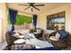 Cozy covered patio with comfortable wicker chairs, pillows, and stylish curtains at 9035 W Villa Chula --, Peoria, AZ 85383