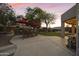 Expansive backyard featuring a built-in bar, mature trees, and a glimpse of the sparkling swimming pool at 9517 E Minton St, Mesa, AZ 85207