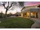 Beautiful backyard with a lush lawn, covered patio, and a glimpse of the pool at twilight at 9517 E Minton St, Mesa, AZ 85207