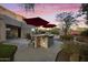 Backyard oasis with a built-in BBQ island, bar seating, red umbrellas, and views of the surrounding mountains at 9517 E Minton St, Mesa, AZ 85207