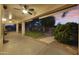 Spacious backyard featuring a covered patio, lush green lawn, mature trees, and scenic sunset views at 9517 E Minton St, Mesa, AZ 85207