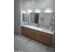 Bathroom featuring an oversized vanity, double sinks, framed mirror, and stylish tile backsplash at 9517 E Minton St, Mesa, AZ 85207