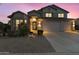 Charming home exterior with landscaped front yard and well-lit two-car garage beneath a picturesque twilight sky at 9517 E Minton St, Mesa, AZ 85207