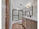 Bathroom featuring a tiled shower, oak vanity, and a decorative mirror at 9807 N 5Th St, Phoenix, AZ 85020