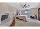 Bright bedroom featuring a fireplace, ceiling fan, comfortable seating, and a cozy bed at 9807 N 5Th St, Phoenix, AZ 85020