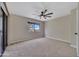 Spacious bedroom featuring a ceiling fan, neutral carpeting, and a window with a view at 9807 N 5Th St, Phoenix, AZ 85020